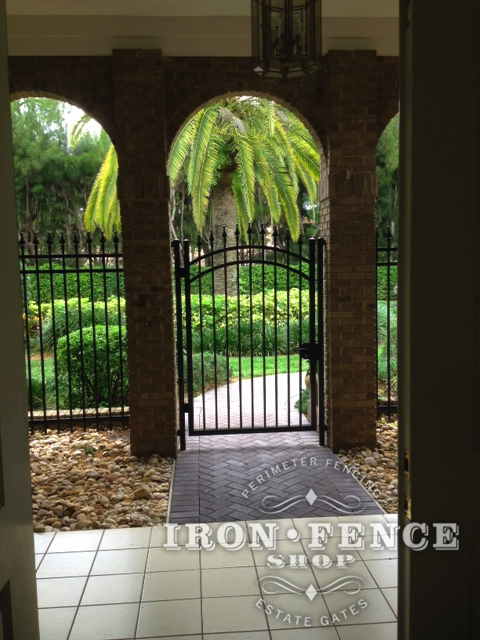 6 Foot Tall Wrought Iron Arched Gate and Fence Installed in a Brick Archway (Signature Grade)