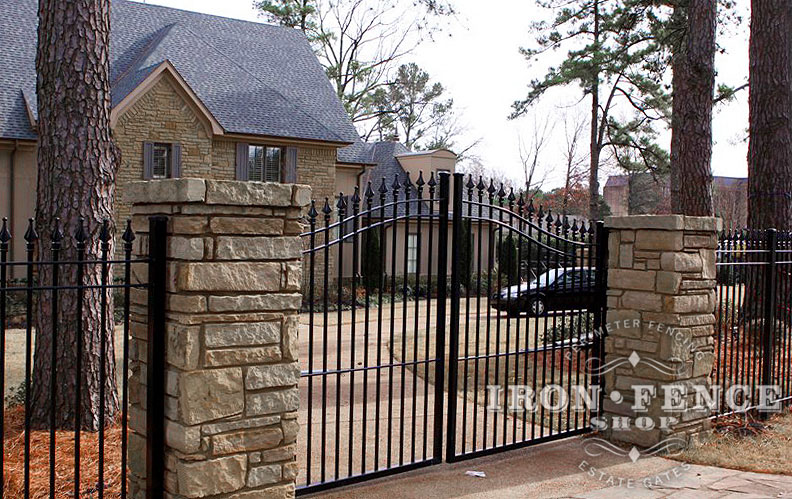 6ft Arching to 7ft Wrought Iron Driveway Gate in a 12ft Width Installed with Stone Columns