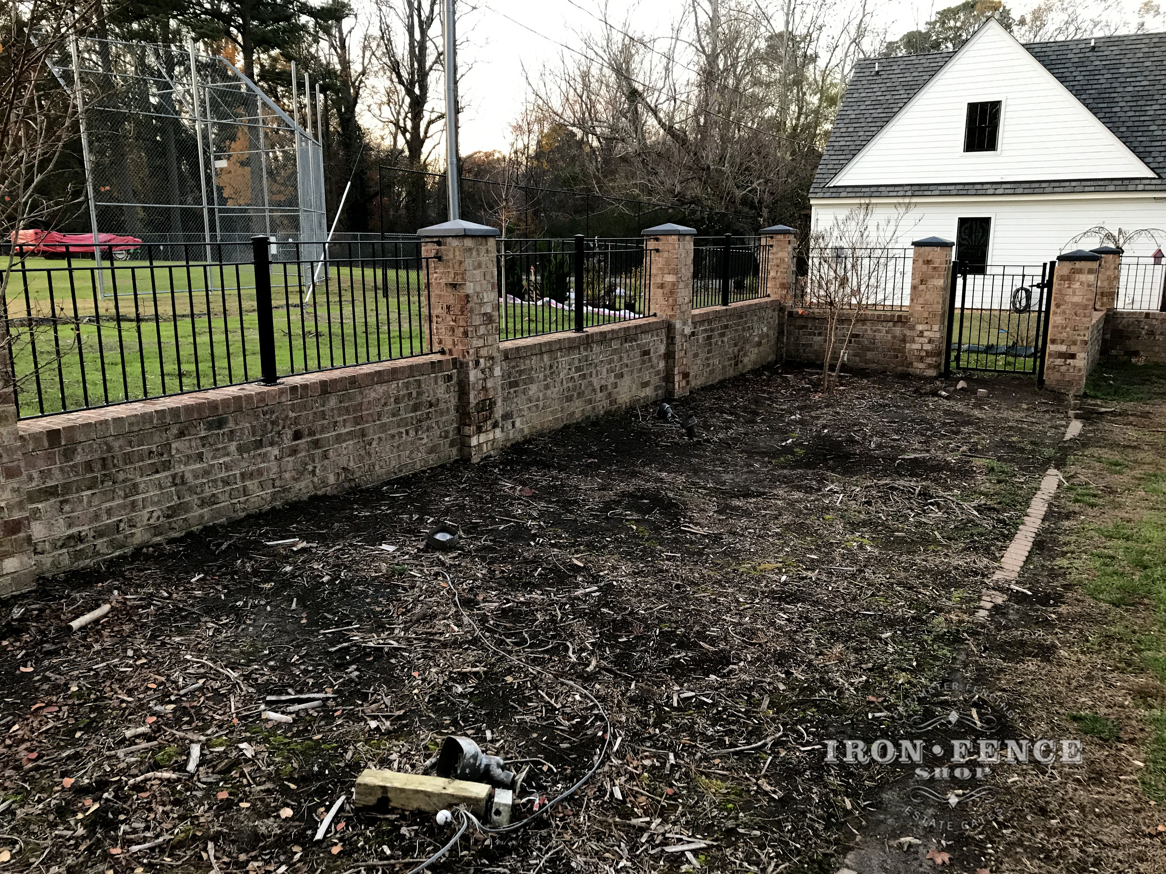 Custom Iron Fence Mounted on a Brick Wall Top and Between Columns