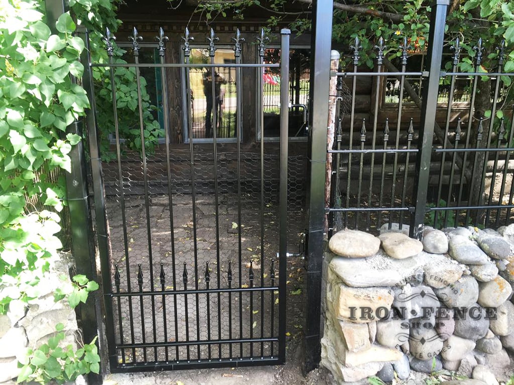 A Custom-Built Iron Gate with Puppy Pickets and Fleur De Lis Finial Tips