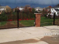 Custom 4ft arching to 5Ft iron driveway gate mounted on brick pillars with matching 4ft iron fence and walk gate (Style #1 - Classic)