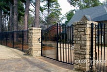 12ft Wide Iron Driveway Gate Mounted on Posts Behind Stone Columns (6' Arching to 7' Height)