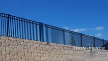 Our 54in Tall Infinity Aluminum Fence Panel in Traditional Grade on Top of a Wall