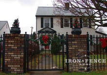 4ft tall iron arched walk gate with custom fleur de lis finials mounted between brick pillars (Style #1 - Classic)