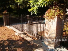 4ft iron hoop and picket style fence stepped for grade between stone columns