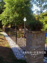 4 foot tall wrought iron hoop and picket style fence between stone pillars