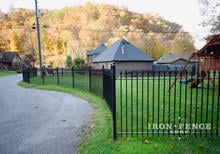 Wrought Iron Fence Angled Around a Curved Road with Straight Panels and Angle Brackets