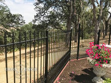 5ft Tall Iron Fence in Puppy Picket Style Angled Around a Corner