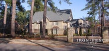 6ft Tall Wrought Iron Fence in Signature Grade with a 12ft Arched Gate Between Stone Columns