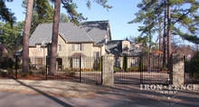 6ft Tall Wrought Iron Fence in Signature Grade with a 12ft Arched Gate (7ft Tall at Center) Between Stone Columns