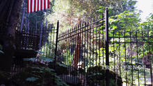 Wrought Iron Fence in Classic Style Installed on a Downhill Incline via Stair-Stepping and Backfilling with Stones