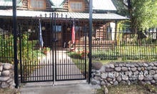 A Custom-Built Arched Iron Gate with Puppy Pickets and Fleur De Lis Finials