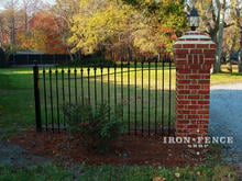 Custom 4ft tall arching to 5ft tall iron fence panel attached to brick column at driveway entrance (Based on Style #1 - Classic)
