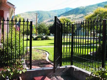 Custom 5ft iron gate and fence with puppy pickets and fleur de lis finials on a wall top (Style #15 - Puppy Picket Finials)