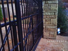 Custom iron slide gate system with decorative iron gate welded to tube frame