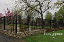 Wrought Iron Fence with Stacked Rock Wall to Handle Grade in the Corner of a Lot