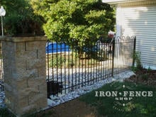 4ft Iron Hoop and Picket style fence surrounding a pool and connecting to stone columns