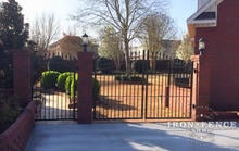 10ft Wide Wrought Iron Gate in 6ft Arching to 7ft Height Installed Between Brick Columns